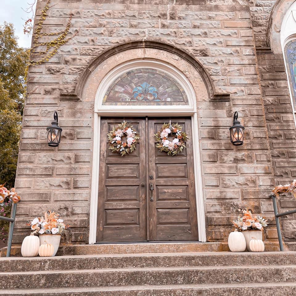 wooden doors with stained glass windows on stone church