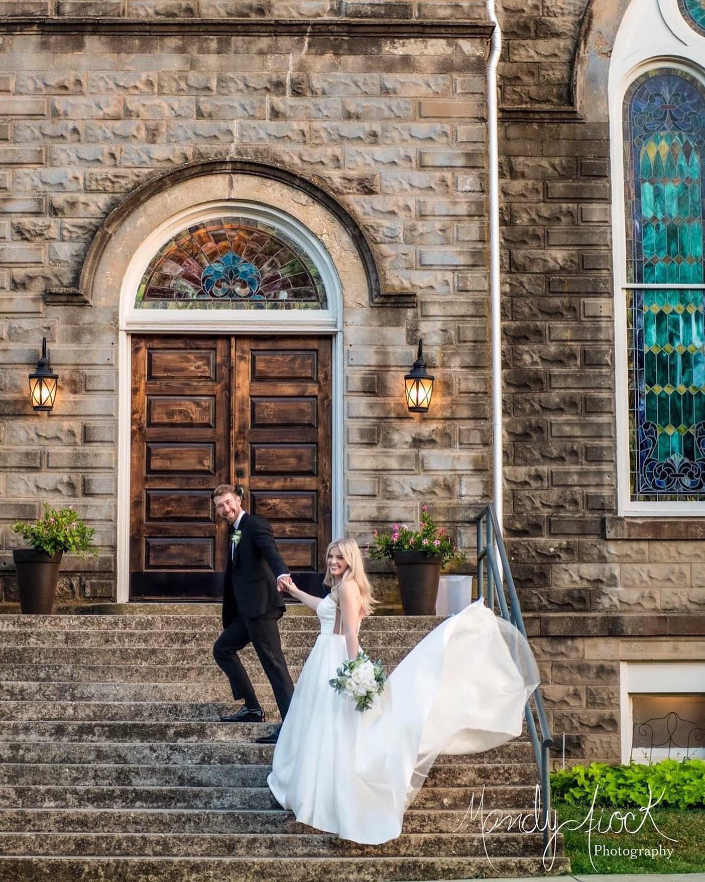bride and groom posing on historic church stone steps