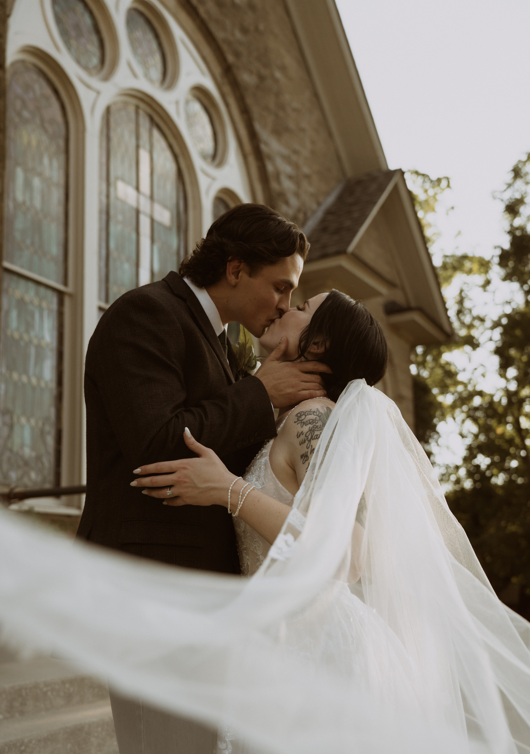 bride and groom kissing outside church