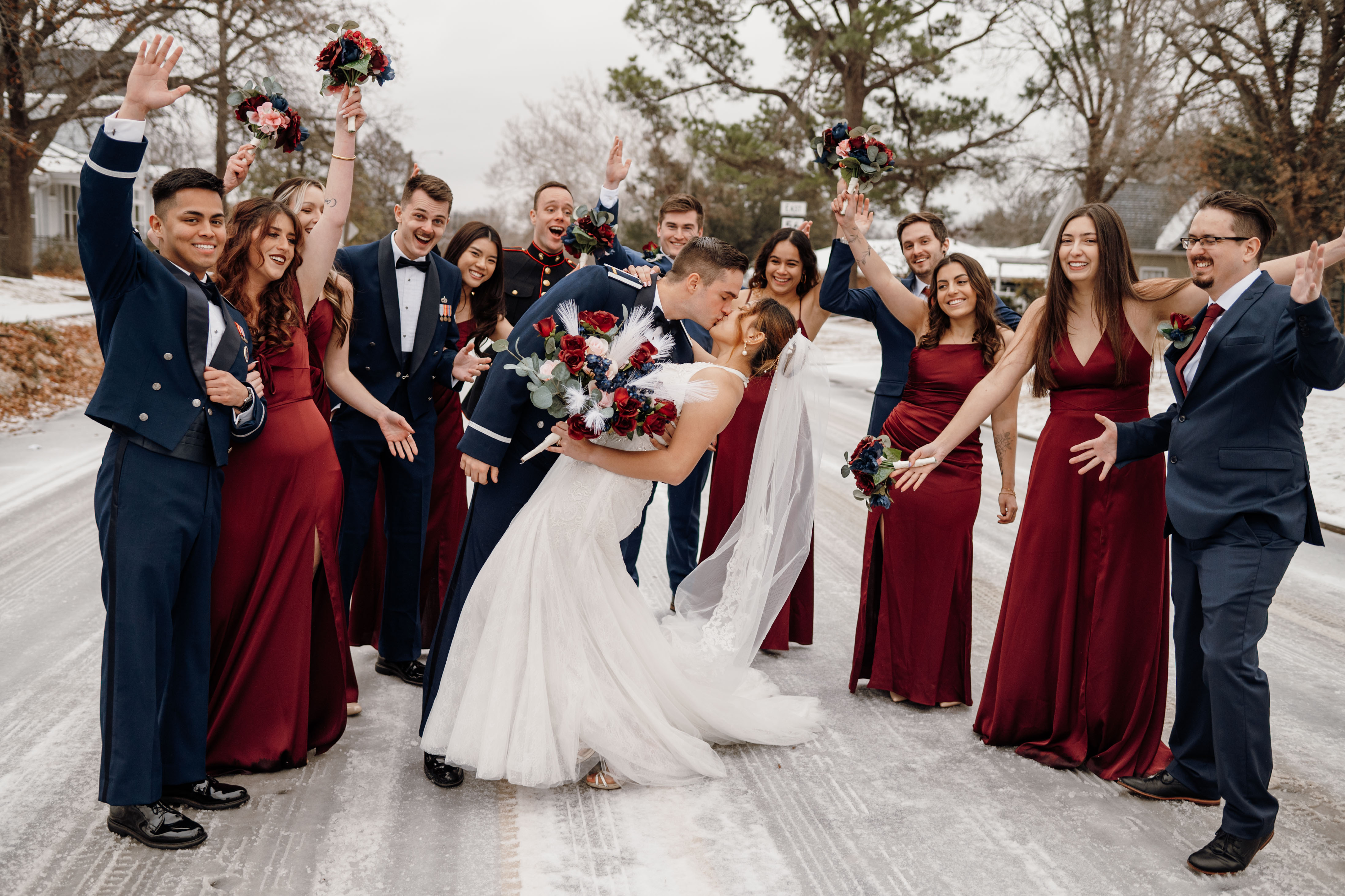 bride and groom kissing while wedding party cheers